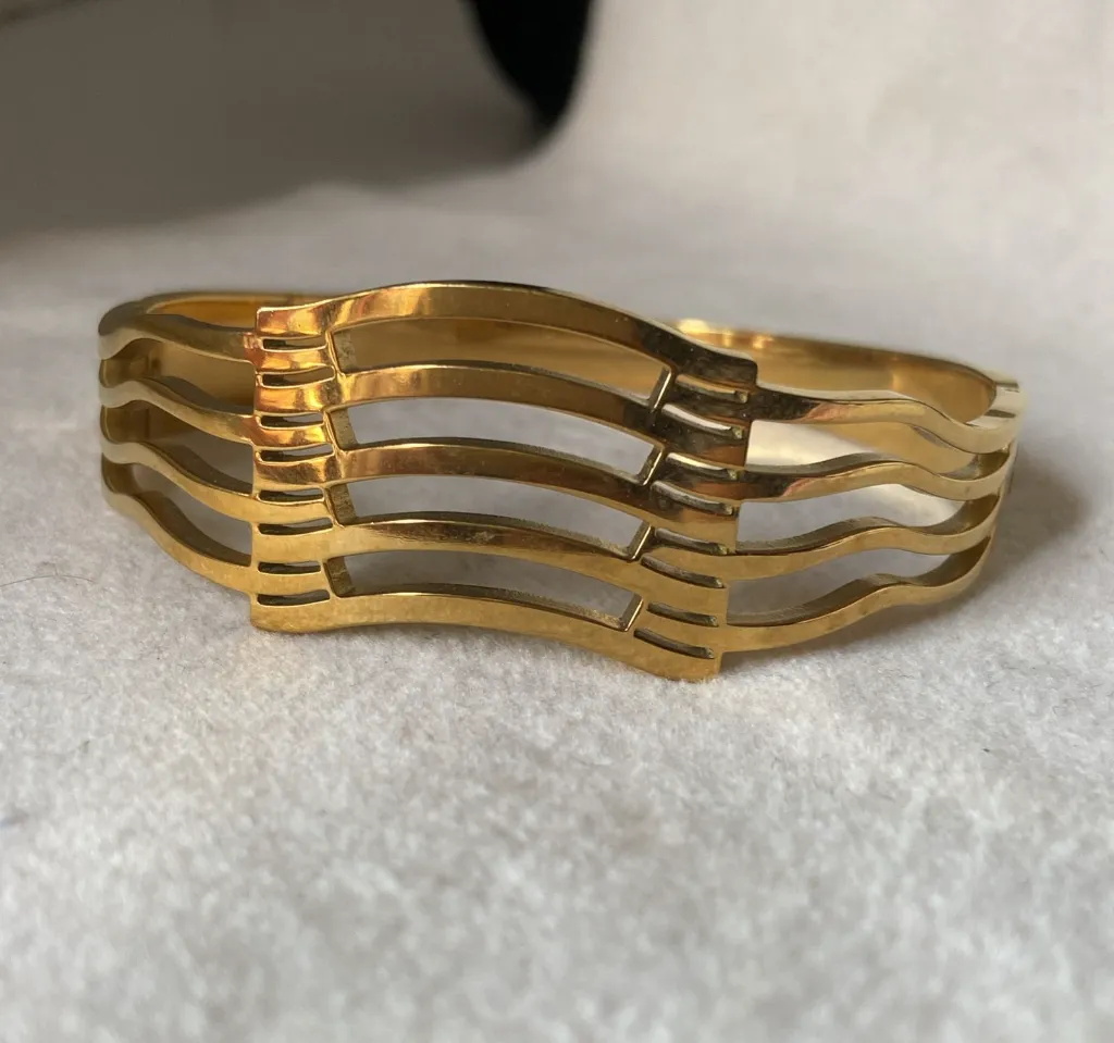 Broad gold bangle bracelet